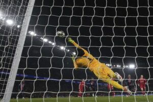 Alisson Becker terbang menyelamatkan gawangnya di laga PSG vs Liverpool di Liga Champions 2024/25, Kamis (06/3/2025). (c) AP Photo/Christophe Ena