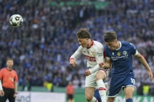 Pemain Arminia Bielefeld, Maximilian Grosser (kanan) berduel udara dengan gelandang Stuttgart, Angelo Stiller. (c) AP Photo/Matthias Schrader