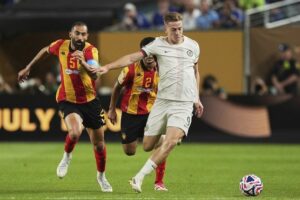 Penyerang Chelsea, Liam Delap dihadang pemain Esperance de Tunis, Yassine Meriah. (c) AP Photo/Matt Slocum
