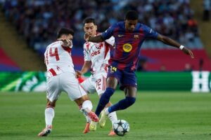 Penyerang Barcelona, Marcus Rashford mencoba melewati adangan dua pemain Olympiakos di laga Liga Champions, 21 Oktober 2025. (c) AP Photo/Joan Monfort
