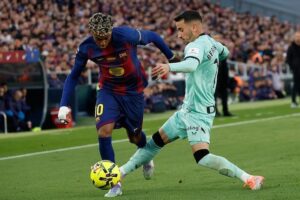 Lamine Yamal (Barcelona) dan Alex Berenguer (Athletic Bilbao) berebut bola dalam laga La Liga di Camp Nou,, 22 November 2025 (c) AP Photo/Joan Monfort