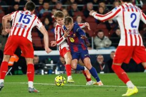 Dani Olmo ditekel Pablo Barrios dalam laga Liga Spanyol antara Barcelona vs Atletico Madrid di Camp Nou, 3 Desember 2025 (c) AP Photo/Joan Monfort