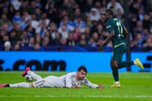 Pemain Manchester City Jeremy Doku berlari di dekat pemain Real Madrid Raul Asencio dalam laga Liga Champions, Kamis, 11 Desember 2025. (c) AP Photo/Manu Fernandez