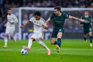 Pemain Real Madrid, Rodrygo (kiri), berebut bola dengan pemain Manchester City Nico Gonzalez dalam laga Liga Champions, Kamis, (11/12/2025). (c) AP Photo/Manu Fernandez