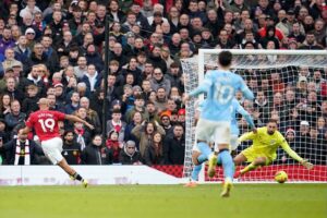 Momen penyerang Man United, Bryan Mbeumo (kiri) mencetak gol ke gawang Manchester City yang dikawal Gianluigi Donnarumma, 17 Januari 2026. (c) AP Photo/Dave Thompson