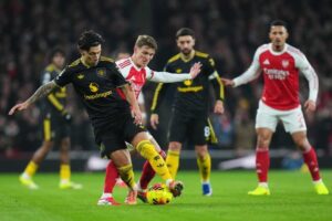 Pemain Manchester United, Lisandro Martinez, melindungi bola dari hadangan pemain Arsenal, Martin Odegaard, dalam pertandingan Premier League, Minggu (25/1/2026). (c) AP Photo/Kirsty Wigglesworth