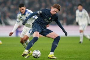 Pemain FC Copenhagen, Mohamed Elyounoussi (kiri), dan pemain Napoli, Scott McTominay, berebut bola dalam pertandingan Liga Champions, Rabu (21/1/2026). (c) Liselotte Sabroe/Ritzau Scanpix via AP