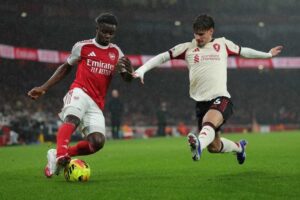 Pemain Liverpool, Milos Kerkez, menghalau pergerakan pemain Arsenal, Bukayo Saka, dalam pertandingan Liga Inggris, Jumat (9/1/2026). (c) AP Photo/Ian Walton