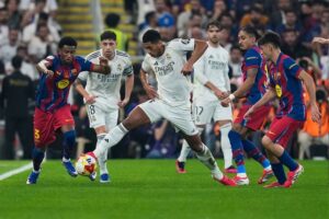 Perebutan bola antara bek Barcelona, Alejandro Balde dengan gelandang Real Madrid, Jude Bellingham di Supercopa de Espana, 12 Januari 2026. (c) AP Photo/Altaf Qadri
