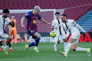 Pemain Barcelona Dani Olmo (tengah) berebut bola dengan pemain Mallorca Vedat Muriqi (kanan) pada laga La Liga/Liga Spanyol antara Barcelona vs Mallorca, 7 Februari 2026 (c) AP Photo/Joan Monfort