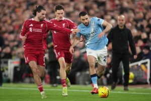 Pemain Liverpool, Dominik Szoboszlai dan Florian Wirtz mencoba menghentikan pergerakan pemain Manchester City Rayan Ait-Nouri. (c) AP Photo/Jon Super
