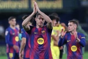 Penyerang Barcelona, Robert Lewandowski, merayakan kemenangan timnya dalam pertandingan La Liga melawan Villarreal, Minggu (21/12/2025). (c) AP Photo/Alberto Saiz